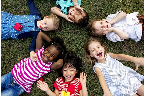 500x332 0051 Group Of Kindergarten Kids Lying On The Grass At Park And Relax With Smiling